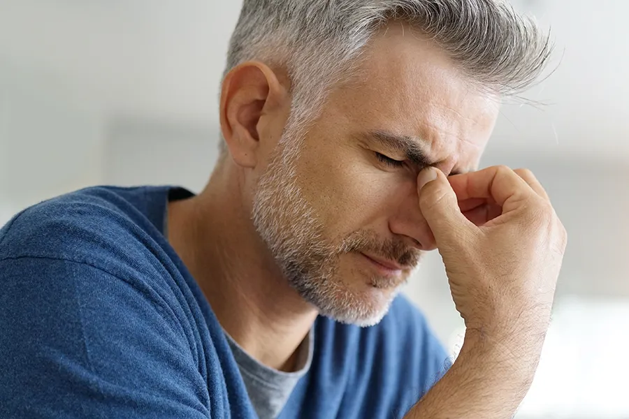 Botox-for-Migraines-Clinic A man suffering from a migraine rubs the bridge of his nose. Get Botox for migraines from Tanya Zboril, NP of TBT Medical in Kitchener-Waterloo.