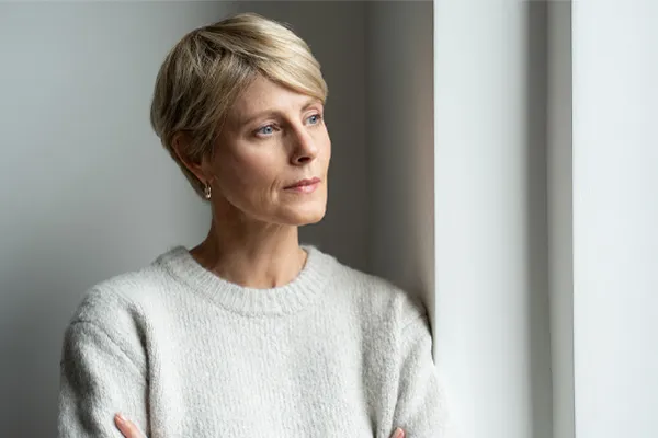 Chronic-Fatigue-Therapy A blond, middle-aged woman looks out the window with a tired expression. Get chronic fatigue treatment from Tanya Zboril, NP of TBT Medical in Kitchener-Waterloo.