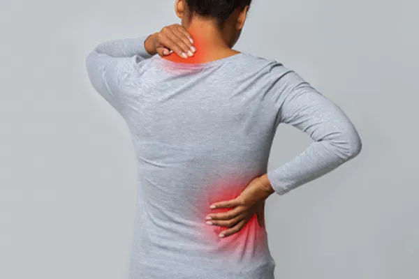 Fibromyalgia-Clinic An image from behind of a woman suffering from Fibromyalgia holding her hands on her neck and lower back. Get fibromyalgia care from Tanya Zboril, NP of TBT Medical in Kitchener-Waterloo.