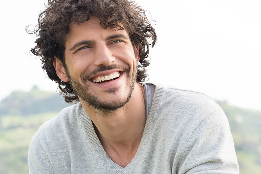 Hair-Loss-Clinic A man with radiant curly hair and a confident smile looks to the horizon. Tanya Zboril, NP of TBT Medical in Kitchener-Waterloo offers effective therapies to support hair regrowth and scalp health to treat hair loss.