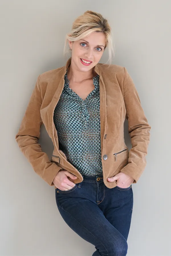 Metabolic-Syndrome-Treatment A smiling blonde woman in a tan leather jacket leans against a gray wall. Schedule metabolic syndrome from Tanya Zboril, NP of TBT Medical in Kitchener-Waterloo.