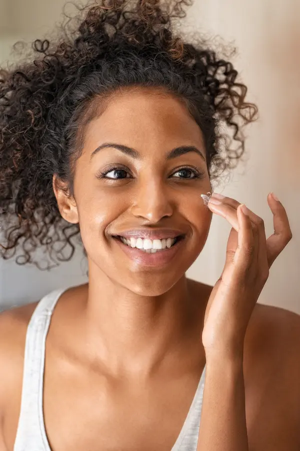 Morpheus8-for-Skin-Treatment A woman applies moisturizer to her face. Get Morpheus8 radiofrequency microneedling treatment from Tanya Zboril, NP of TBT Medical in Kitchener-Waterloo.