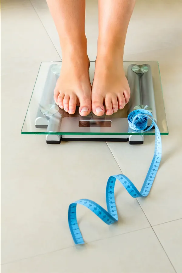 Ozempic-Treatment Feet on a scale with a measuring tape for weight loss. Get Ozempic for weight loss from Tanya Zboril, NP of TBT Medical in Kitchener-Waterloo.