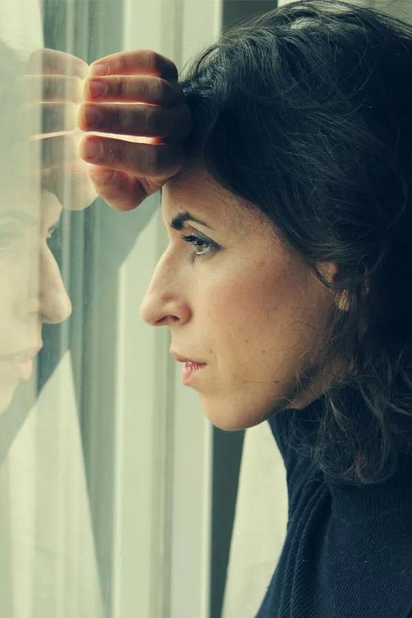 PCOS-Treatment A brunette woman in a thin dark turtleneck looks out the window with a serious expression, suffering from PCOS. Get treatment for Polycistic Ovarian Syndrome/PCOS from Tanya Zboril, NP of TBT Medical in Kitchener-Waterloo.