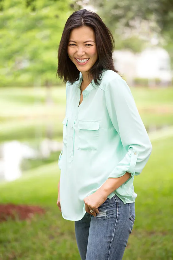 Perimenopause-Treatment A middle-aged brunette woman in a light green button-up shirt stands outside smiling, happy with her perimenopause treatment from Tanya Zboril, NP of TBT Medical in Kitchener-Waterloo.