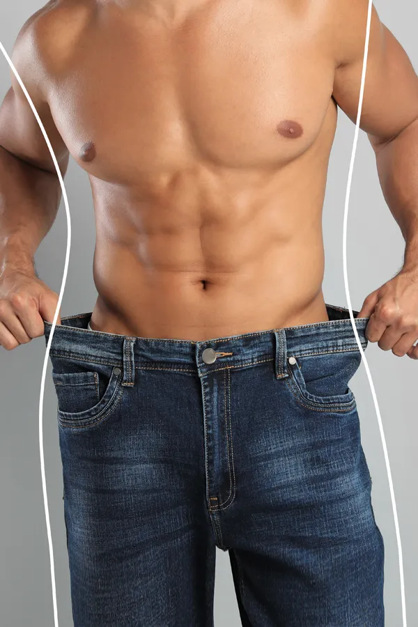 Semaglutide-Weight-Loss-Treatment A strong shirtless man in jeans holds the waistlines of his too-big jeans to show the success of semaglutide weight loss from Tanya Zboril, NP of TBT Medical in Kitchener-Waterloo.
