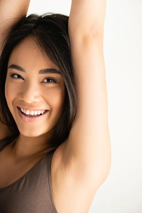 Underarm-Sweat-Treatment A vibrant woman smiling at the camera with her arms up, representing Botox for Excessive Sweating treatment offered by Tanya Zboril, NP of TBT Medical in Kitchener-Waterloo.